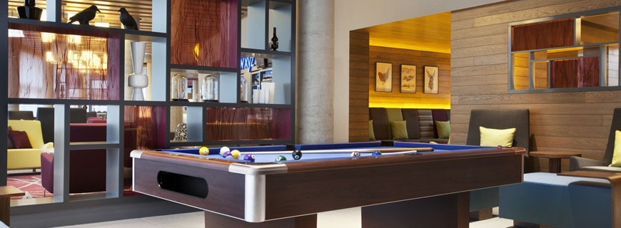 Billiardtisch vor Regal mit bunten Accessoirs