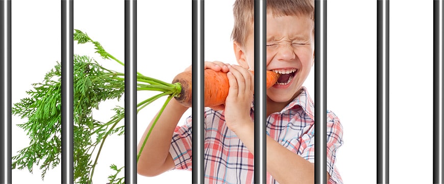 Kind mit Karotte hinter Gittern