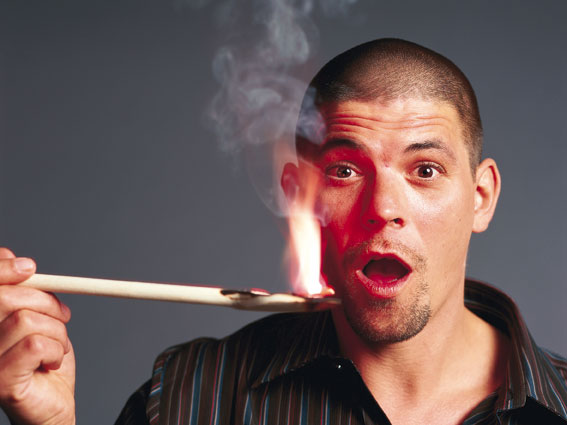 der Erfolgreiche TV-Koch Tim Mälzer mit einem brennenden Stab, sein Mund zu einem O geformt vor staunen 
