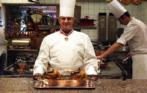 Paul Bocuse in der Küche mit einem Silbertablett voller kulinarischer Köstlichkeiten 