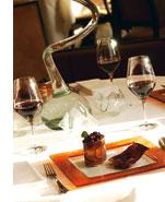 ein klassisch gedeckter Tisch mit Wein und einer kulinarischen Kreation 