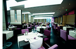ein modernes Restaurant mit futuristischer Einrichtung, alles in weiss-violetten Farben gehalten 