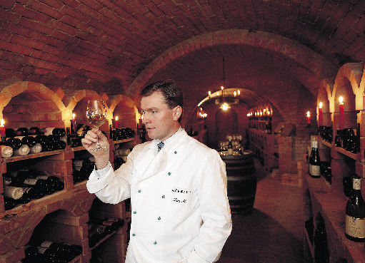 Toni Mörwald mit einem Weinglas im Weinkeller 