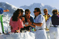 Ein Event in den Bergen ist zu sehen, Menschen genießen die Sonne und Getränke im Alpenraum 
