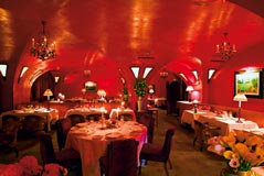 ein Restaurant in einem gewölbten Raum gänzlich in rotem Licht schimmernd 
