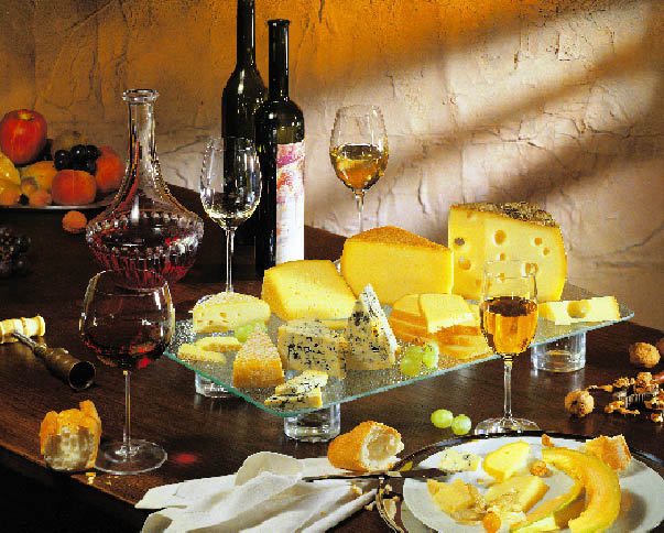 Wein, eine Käseplatte und Weintrauben auf einem Tisch 