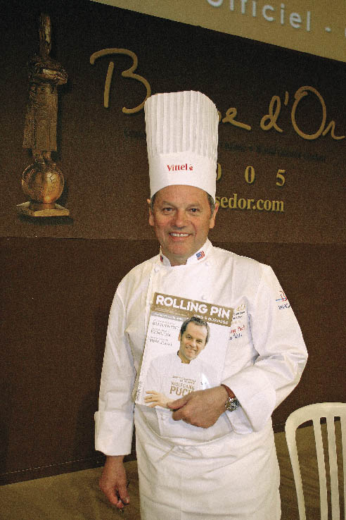 Wolfgang Puck posiert mit einer Ausgaben des Rolling Pins mit Ihm als Coverbild 
