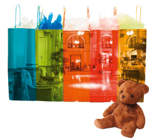 ein Stoffteddy, Einkaufstueten in verschiedenen Farben und kunstvollen Aufdruecken