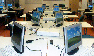 ein Computerraum mit mindestens zehn bildschirmen 