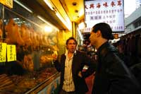 Trettl und ein Kollege vor einem chinesischen Restaurant in Hong Kong wo in der Auslage tote Enten hängen 