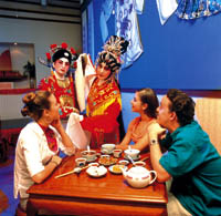 eine Gruppe beim essen, während es eine Vorstellung eines traditionellen Tanzes gibt. 