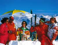 Menschen genießen das schöne Wetter und die kühlen Drinks auf der Skihütte unter strahlend blauem himmel 