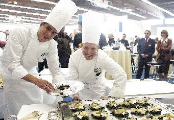 zwei junge köche präsentieren ihre kulinarischen köstlichkeiten 