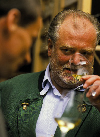 Ein Herr bei der Weinverkostung riecht an seinem Weißweinglas 