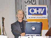 Ein Herr sitzt vor seinem Laptop vor dem ÖHV Banner 