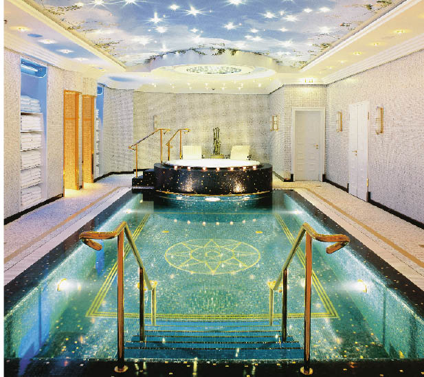 ein swimmingpool mit arabischen mosaiken verziehrt gefolgt von einem whirlpool 