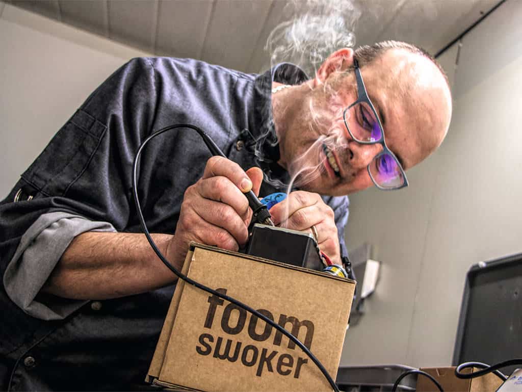 Küchenchef, Technikfreak und Erfinder: Marcel Blättler beim Löten am Prototyp des Räuchergeräts Foom.