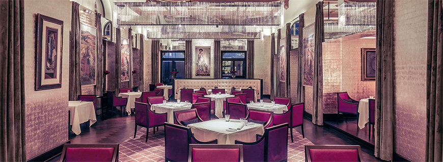 Interieur im The Restaurant: rote Stühle, Bilder an den Wänden und weiße Tischdecken