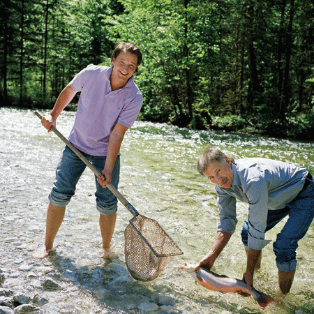 Andreas Döllerer und ein zweiter Mann im Fluss mit Netz am Fischen 