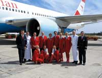 die crew der austrian airlines posiert in uniform für ein foto vor einem flugzeug